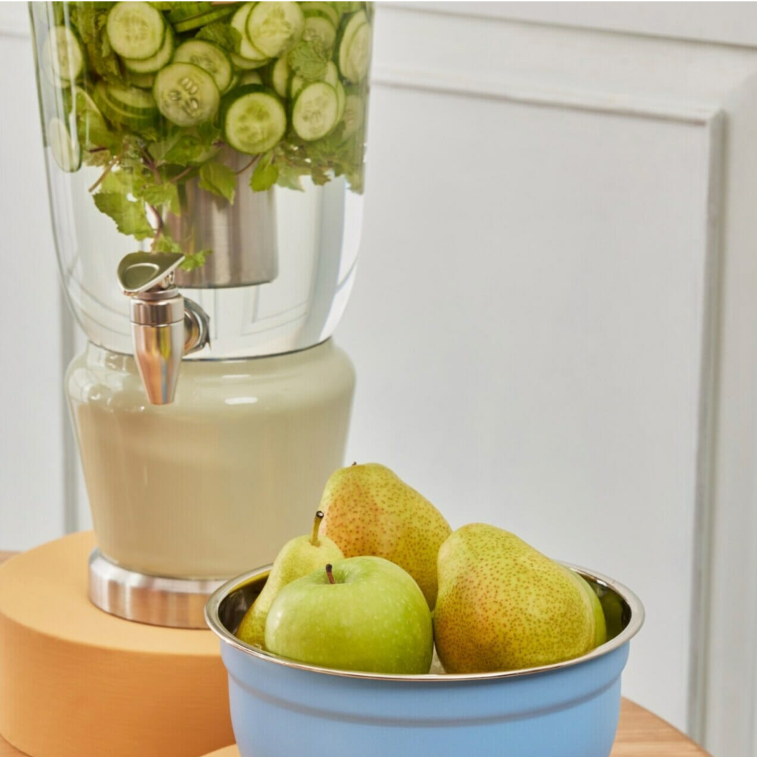 Mellow Sage Luminique dispenser in subtle mint green infused with cucumber and basil water set alongside a bowl of pears